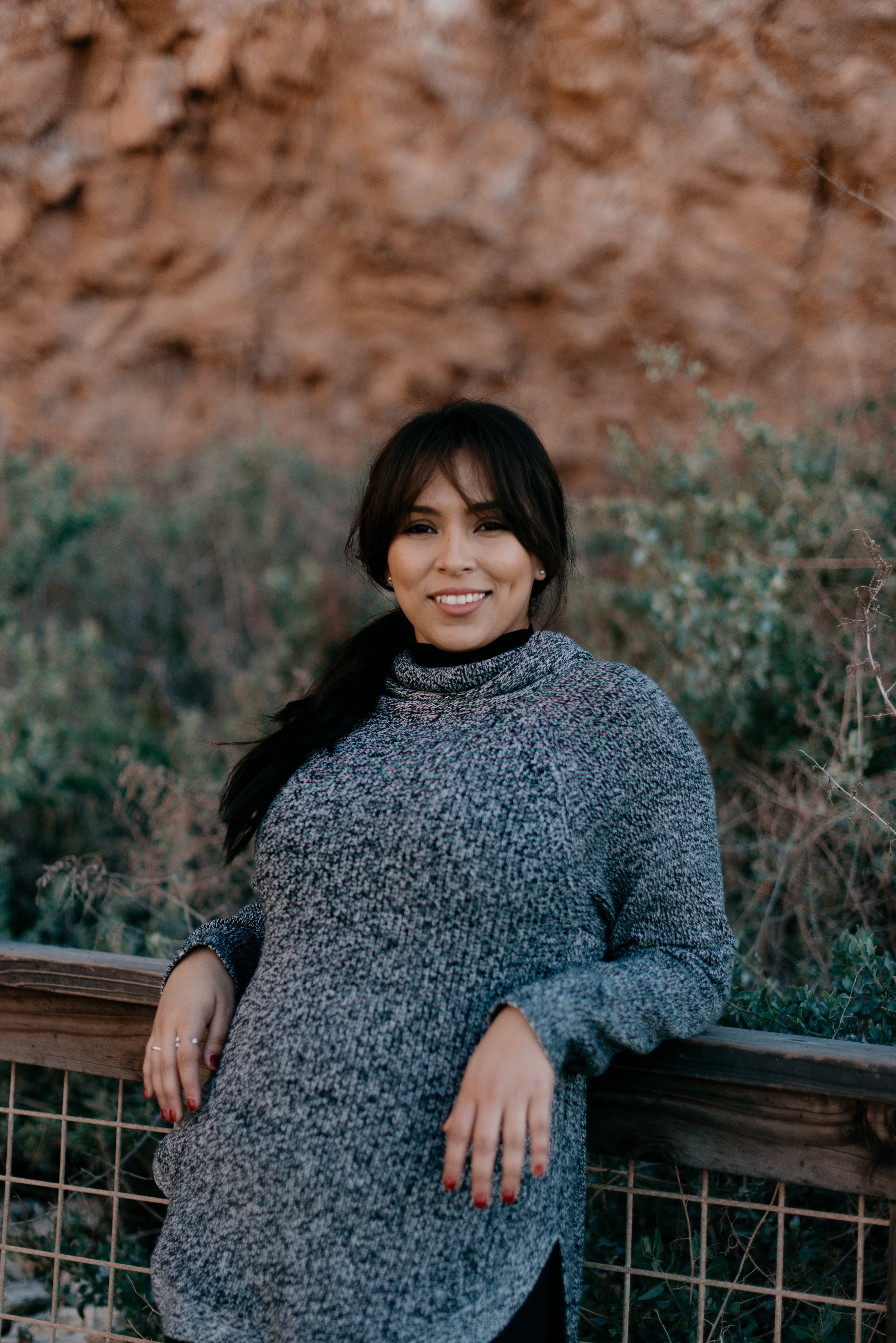 files/woman-in-grey-sweater-smiles-and-leans-against-a-railing.jpg
